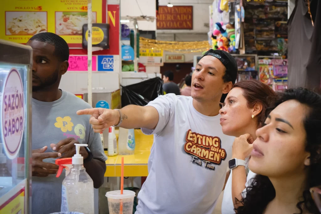 An Eating With Carmen Food Tours guide leading guests through a Mexico City market